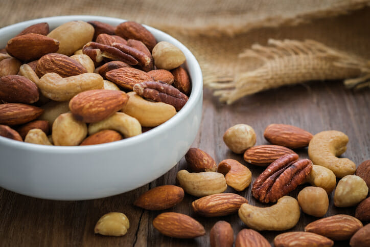 Mixed nuts on wooden table and bowl