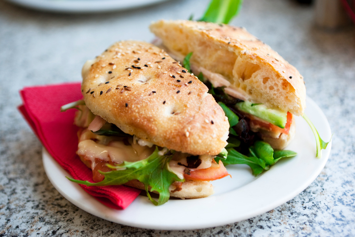 A gourmet ham sandwich on turkish bread at a modern delicatessen.