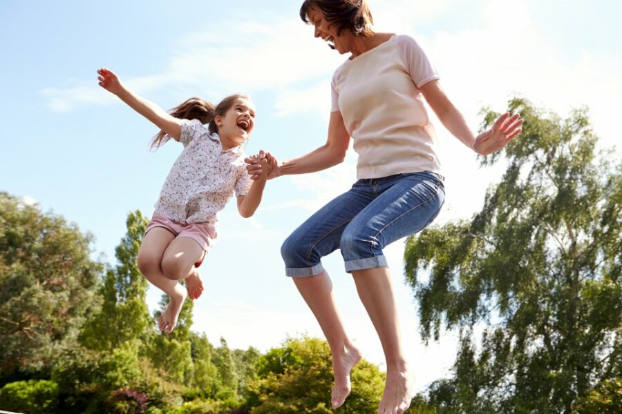 Mother-And-Daughter-Bouncing-On-Trampoline-Together