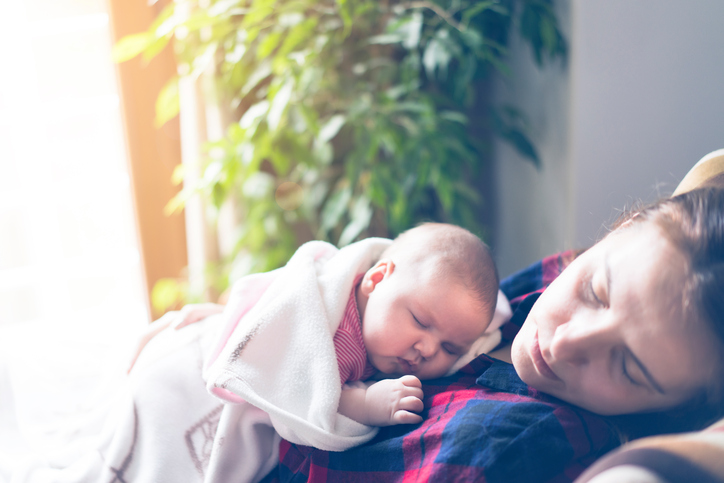 Newborn baby lying on her mother's chest