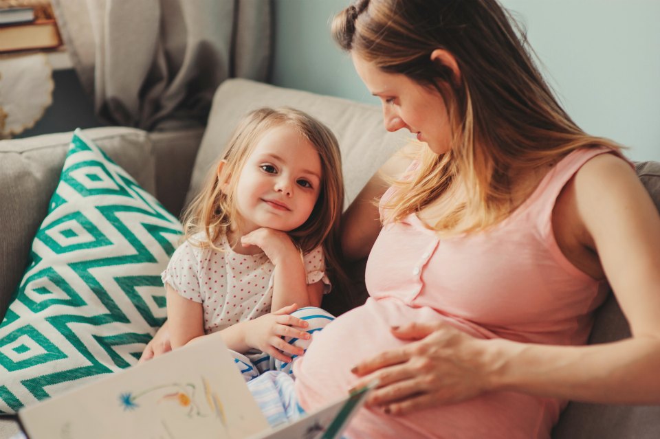 pregnant mum reading to daughter