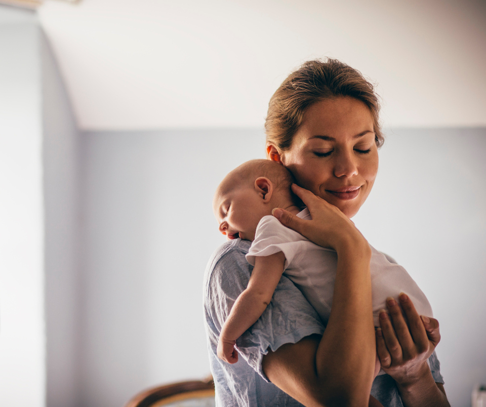 mum hugging newborn sleepling