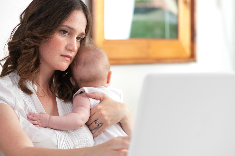 Mother working from home with baby looking stressed