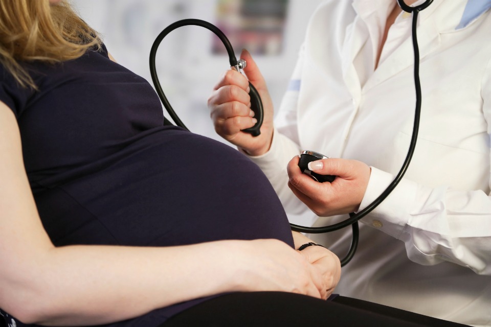 Pregnant woman having her blood pressure checked by the doctor