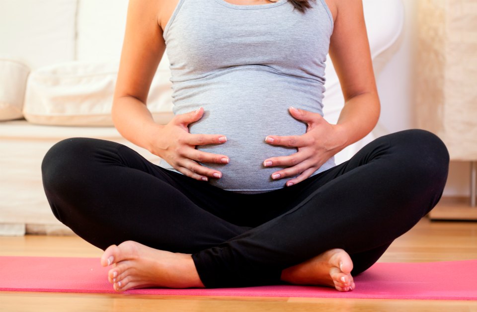 pregnant woman on yoga mat