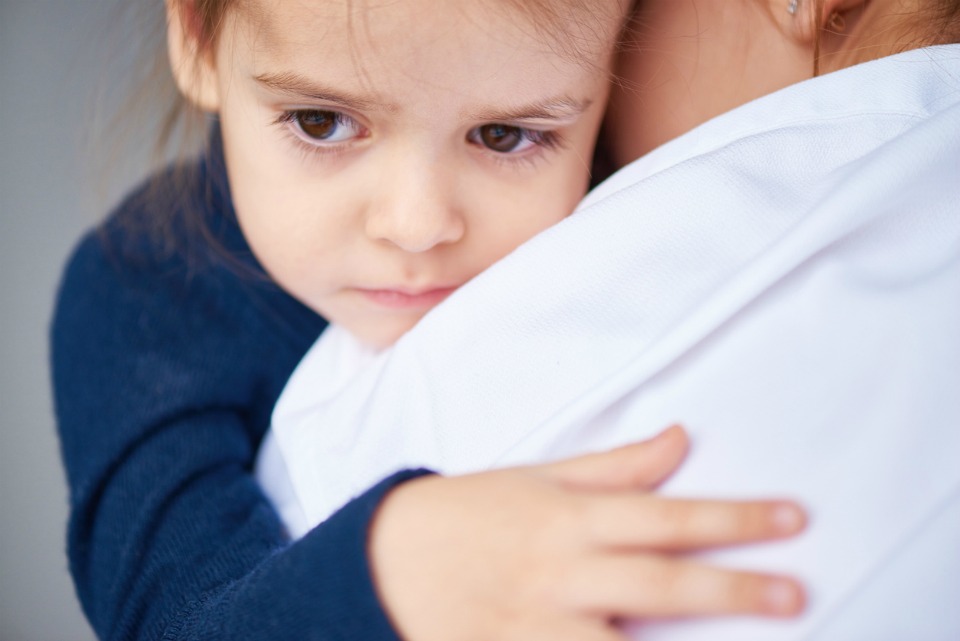 Sad girl hugging mother tightly