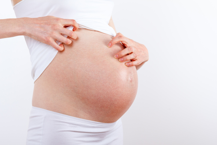 pregnant woman scratches itchy belly