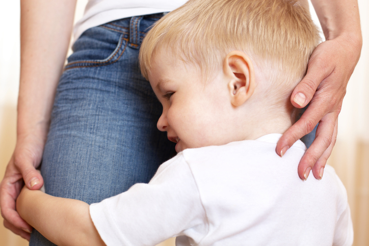 boy holding her mother's legs