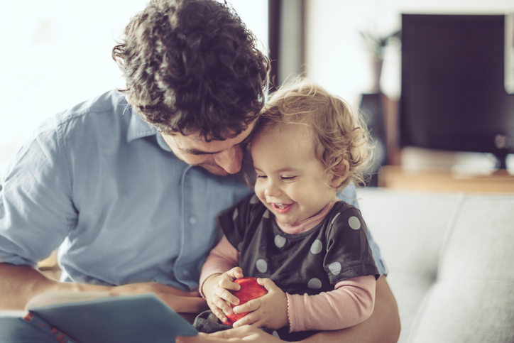 dad reading a book to child