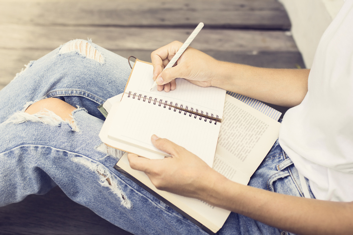 Girl sitting on floor and wrote in a notebook