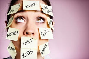 Frustrated woman covered in stiocky reminders rolls her eyes