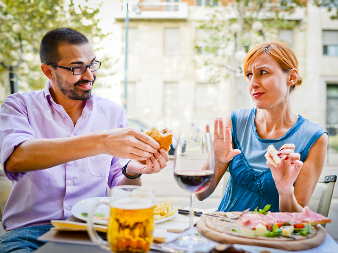 Couple Eating in Outdoors cafe: Woman refuses to eat burger