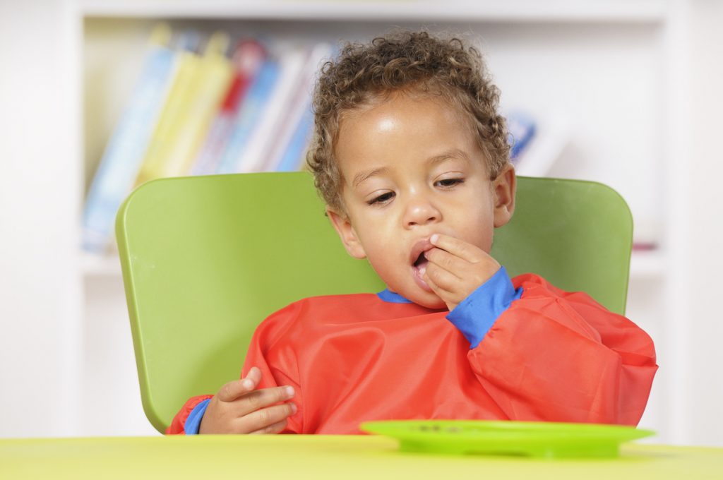 A biracial baby boy/ toddler sitting at the table and eating in a nursery setting.http://images.eu.viewbook.com/e4dc2466aaa35ecbcdd14f75226f8999.jpg