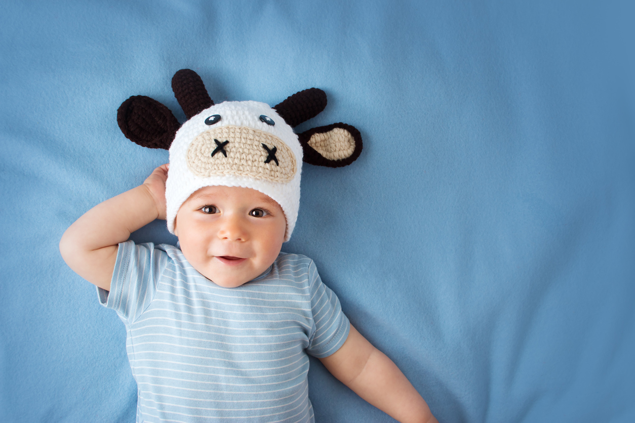 cute baby in a cow hat on blue blanket