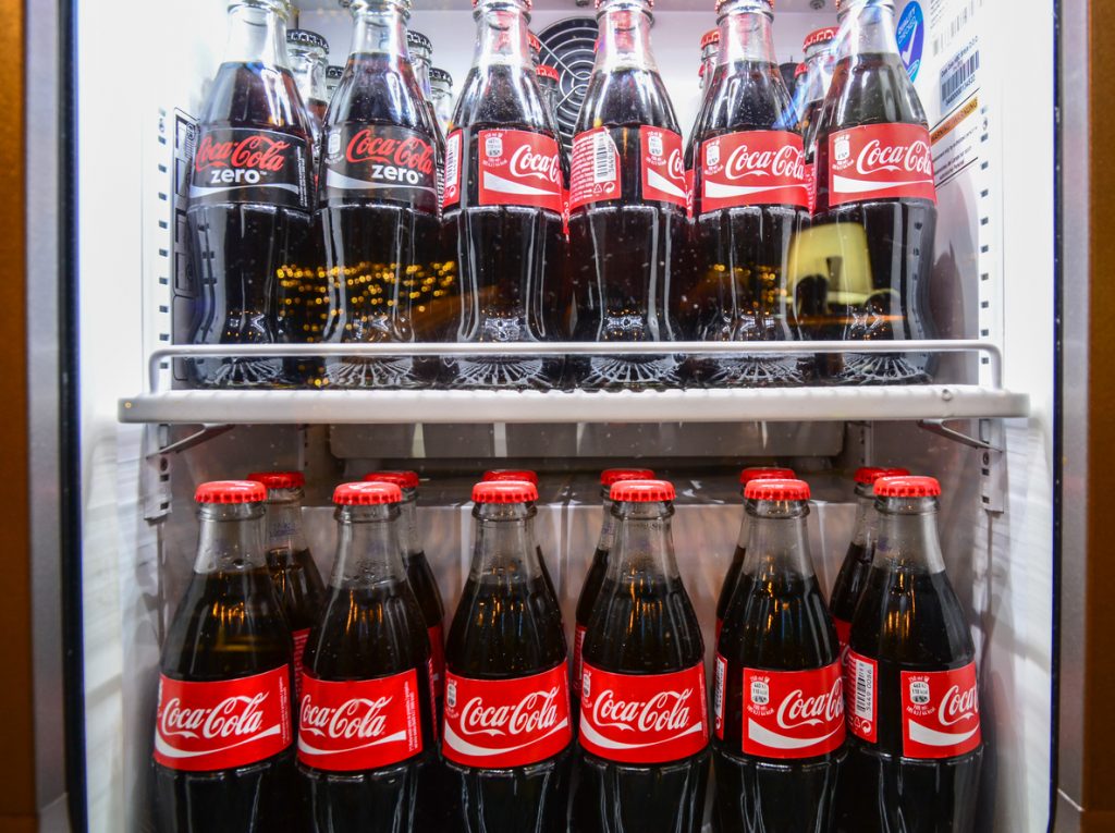 Subotica, Serbia - March 9, 2016: Glass bottles of famous coca-cola drink in the fridge. Picture was taken in Alloro, one of the restaurants in Subotica, Serbia. Photographed through fridge window.