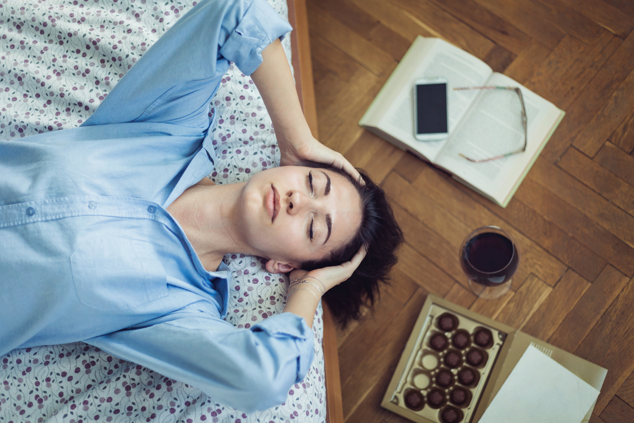 Girl lying on her bed with her eyes closed and thinking