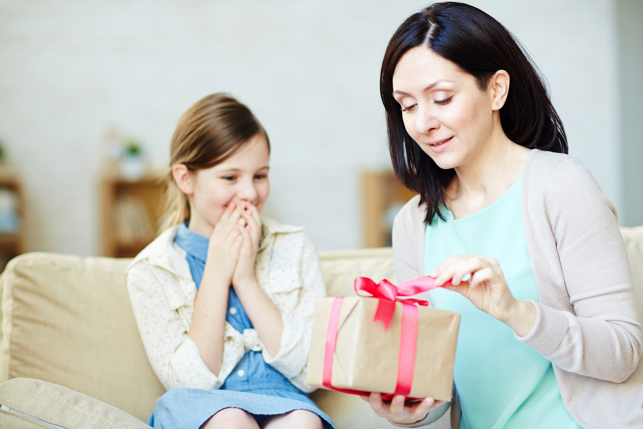 Mother looking at box with her daughter gift