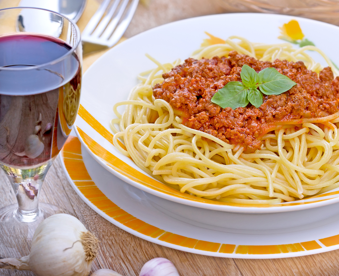 Spaghetti Bolognese and red wine on table