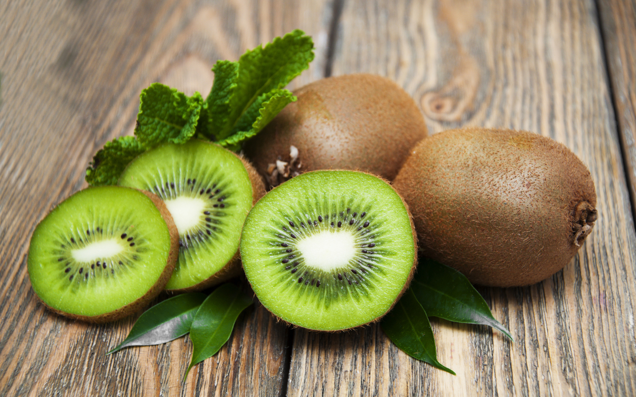 Ripe fresh kiwi on wooden background