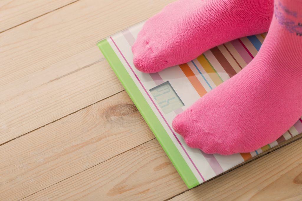 Feet on scales on wooden floor