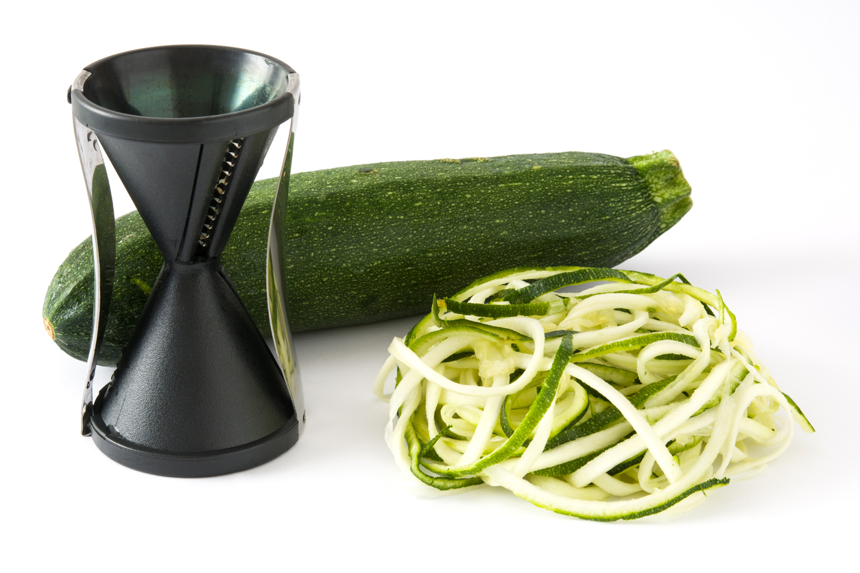 Zucchini noodles and spiralizer isolated on white background