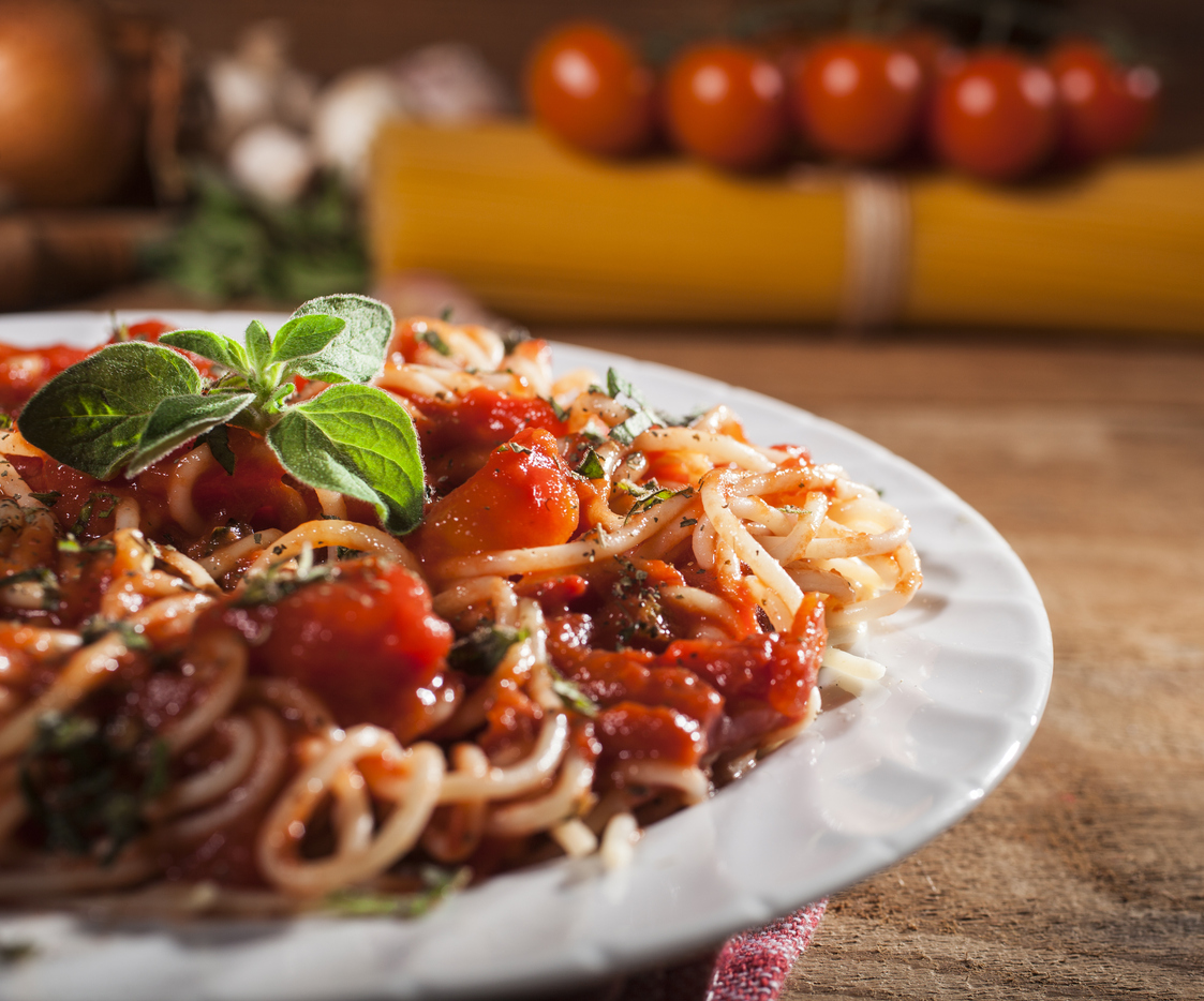 Spaghetti pasta with meatballs and tomato sauce on wooden background