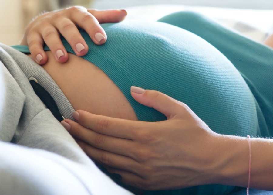 Photo of pregnant woman sleeping on the blue couch