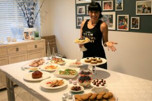 Mum standing behind table with Christmas treats and meals on it