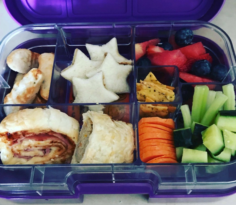 A colourful lunchbox with salad and sandwiches 