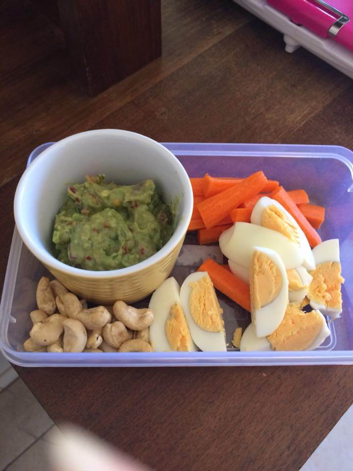 Firm boiled egg with carrot sticks and avocado