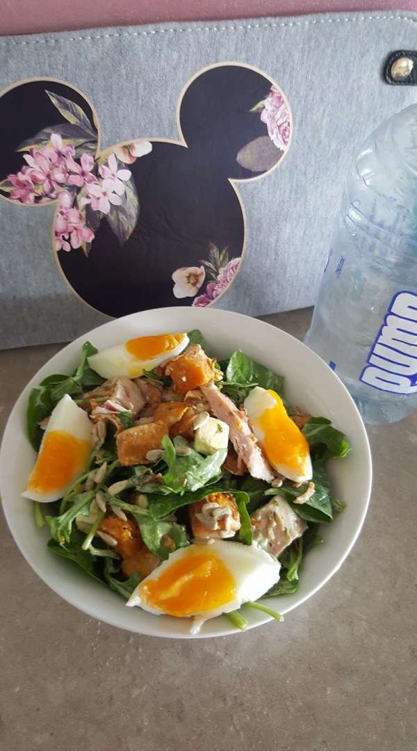 Medium boiled egg in a green salad