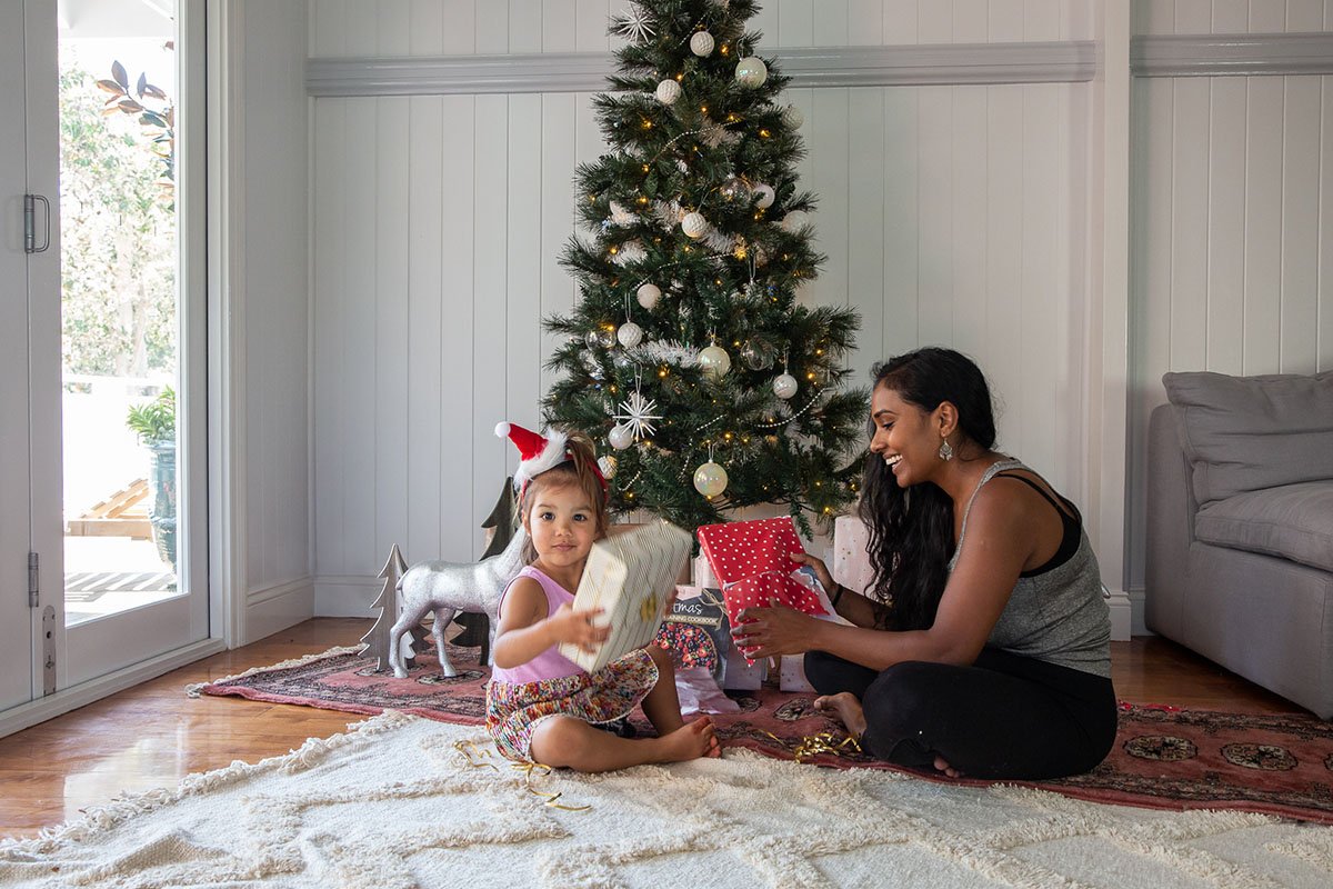 mum and child under christmas tree with presents