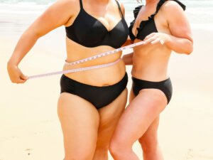 Zena-and-bec-measuring-tape-on-beach-fear-weight-loss