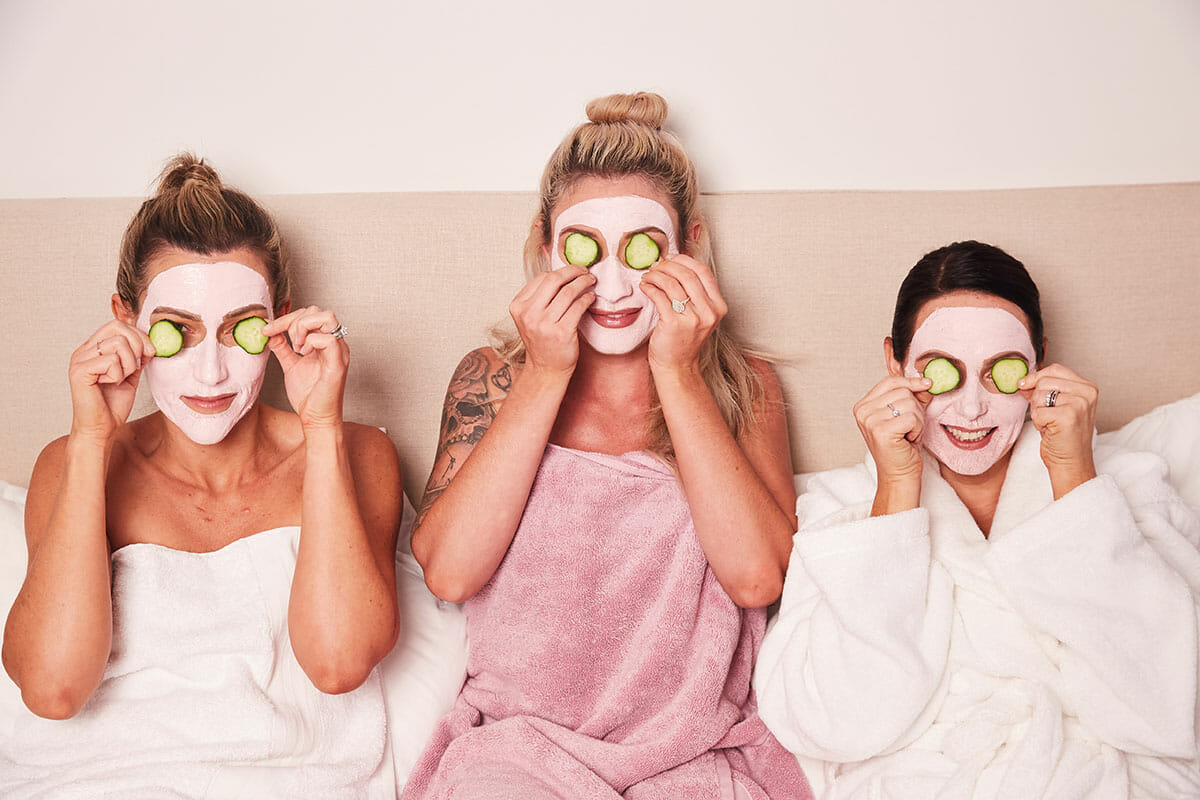 three women doing a pink clay mask in bed menopause affects skin