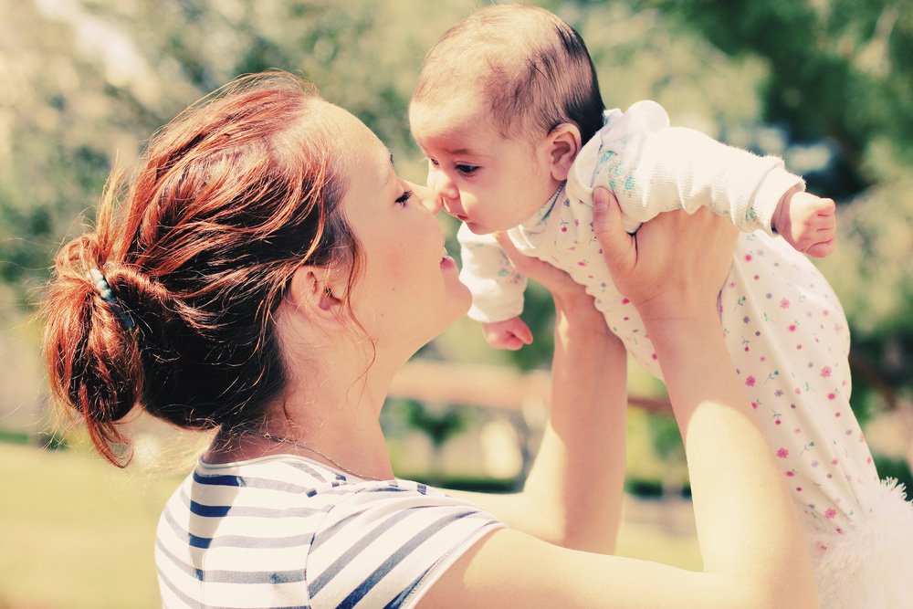 mother-holding-her-baby-outside-l