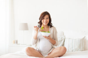 pregnant-woman-eating-food-on-a-bed-pregnancy-food