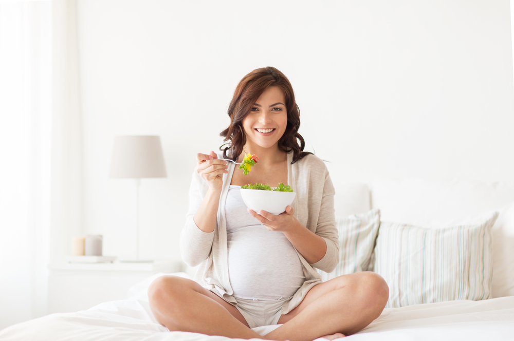 pregnant-woman-eating-food-on-a-bed-pregnancy-food