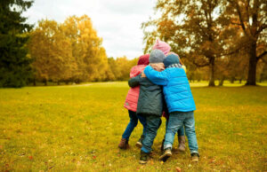 kids-hugging-in-park-cover-the-cost-of-kids