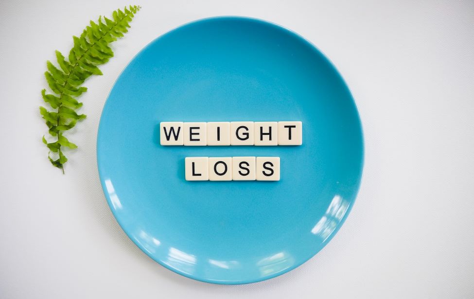 Weight loss on a blue plate spelt with scrablle letters