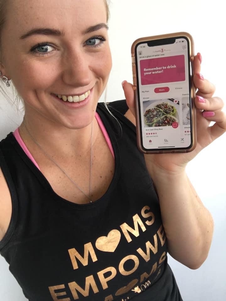 Mum holding 28 Day Weight Loss Challenge app.